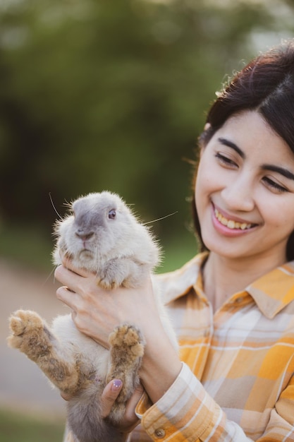 Piękny ładny Portret Młodej Azjatyckiej Kobiety Osoby Z Uroczym Królikiem W Koncepcji Opieki Nad Zwierzętami I Zwierzętami Szczęśliwa Kobieta Trzyma Królika W Przyrodzie Na Zewnątrz Pola Z Przyjaźnią Wielkanocną Koncepcją