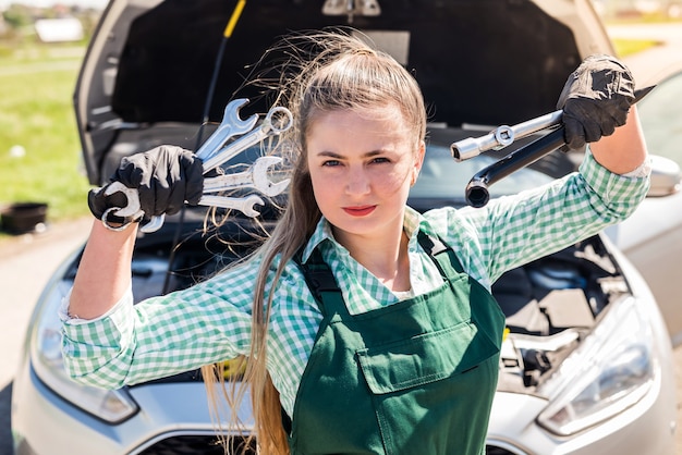 Piękny Mechanik Pozuje Z Różnymi Narzędziami Przed Samochodem