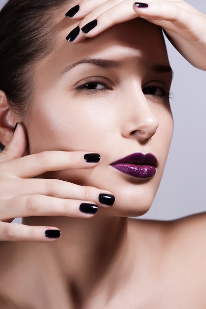 Zdjęcie piękny młody model z jasnym makijażem i manicure