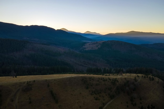 Piękny panoramiczny krajobraz górski z mglistymi szczytami i mglistą doliną przy zachodzie słońca