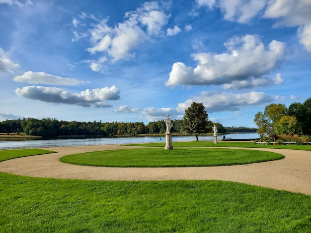 Piękny park krajobrazowy o zachodzie słońca zielony trawnik w letni dzień pochmurne niebo zachodzące słońce