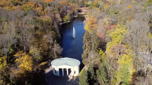 Piękny park krajobrazowy z drzewami fontannowymi jeziora i białą architekturą na drzewach w słoneczny jesienny dzień