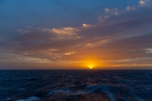 Piękny pejzaż morski - fale i niebo z chmurami z pięknym oświetleniem. Złota godzina. Zachód słońca na morzu.