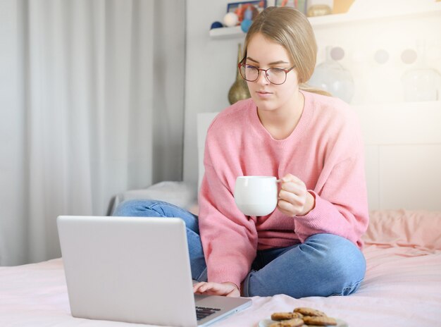 Piękny Portret Niezależny Młoda Kobieta Siedzi Relaks I Wypoczynek Pracujący Komputer Laptop Internet Online Na łóżku W Sypialni, Wesoła Dziewczyna Z Gestem Zadowolony I Sukces, Koncepcja Stylu życia.