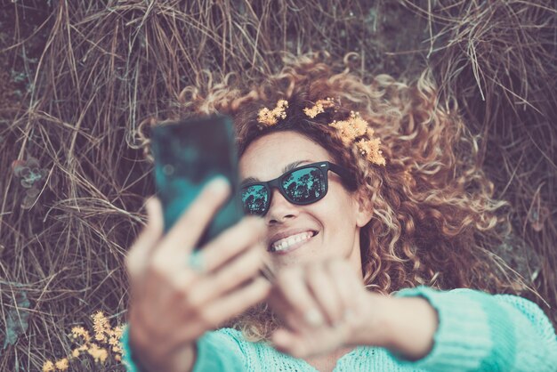 Piękny portret szczęśliwej wesołej kaukaskiej kobiety robi zdjęcie selfie z nowoczesnym telefonem