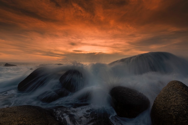 Piękny Seascape z morzem i skałą na zmierzchu tle.