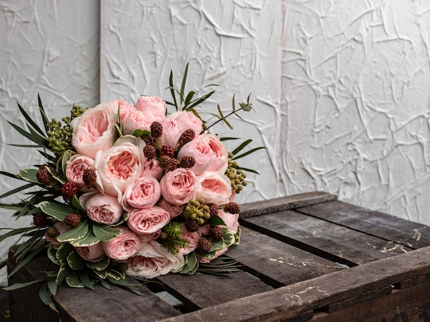 Piękny ślubny bukiet krzewów i piwonii delikatnie różowych róż.