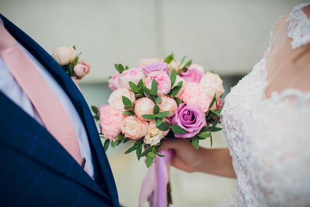 Piękny ślubny bukiet w rękach panny młodej. Hortensja, eustoma, róże w bukiecie panny młodej.