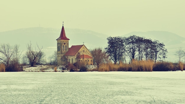 Zdjęcie piękny stary kościół św. linharta katolicka świątynia wioska musov pasohlavky czechy zdjęcie krajobrazu z zachodem słońca na tamie new mills nove mlyny