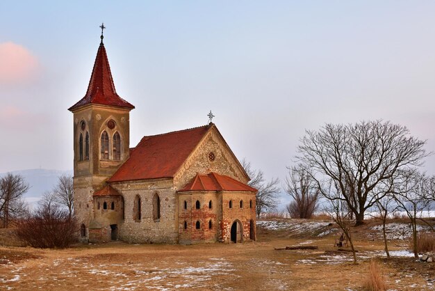 Zdjęcie piękny stary kościół św. linharta katolicka świątynia wioska musov pasohlavky czechy zdjęcie krajobrazu z zachodem słońca na tamie new mills nove mlyny