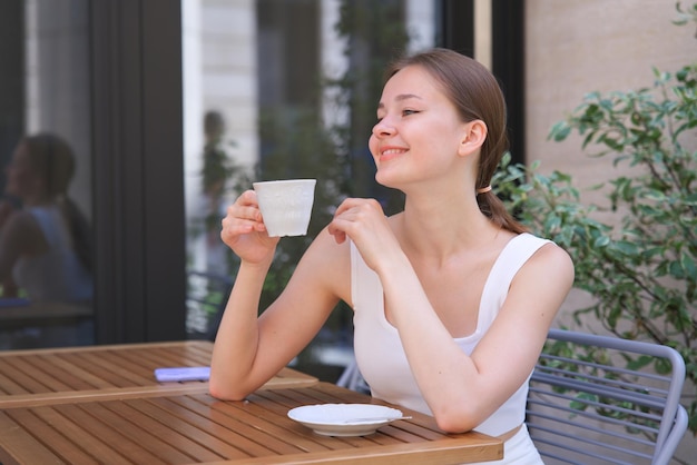 piękny szczęśliwy pozytywny radosny uśmiechnięta dziewczyna młoda kobieta na zewnątrz picie napój herbata kawa