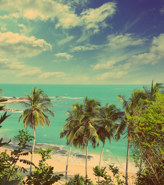 piękny tropikalny krajobraz plaży z turkusowym morzem i chmurami w stylu vintage retro