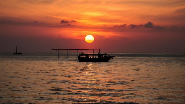 Piękny ujęcie zachodu słońca nad morzem z łodzią w środku