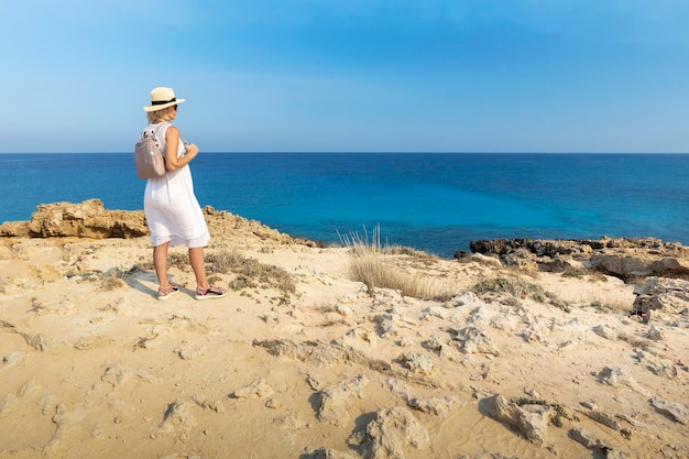 Piękny widok kobiety wędrującej po plaży, wyspa Cypr, popularny cel letnich podróży po Europie.