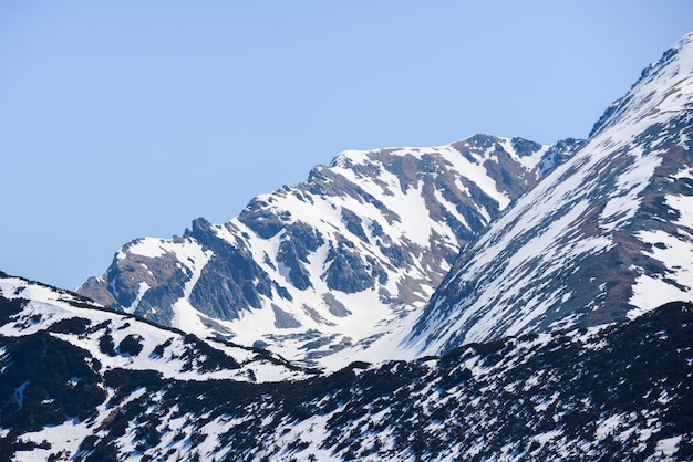 Piękny widok na ośnieżone góry z błękitnym niebem, w słoneczny dzień na wiosnę. Tatry Zachodnie.