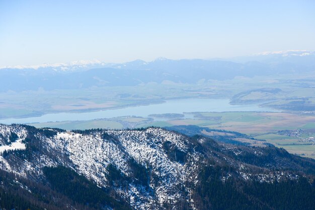 Piękny widok na ośnieżone góry z błękitnym niebem, w słoneczny dzień na wiosnę. Tatry Zachodnie.