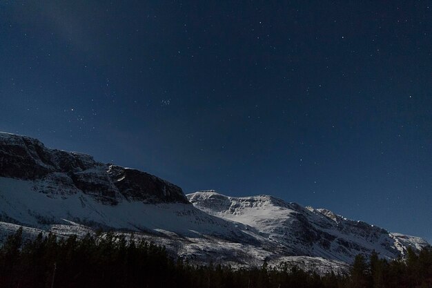Piękny widok pokrytych śniegiem gór na tle nocnego nieba