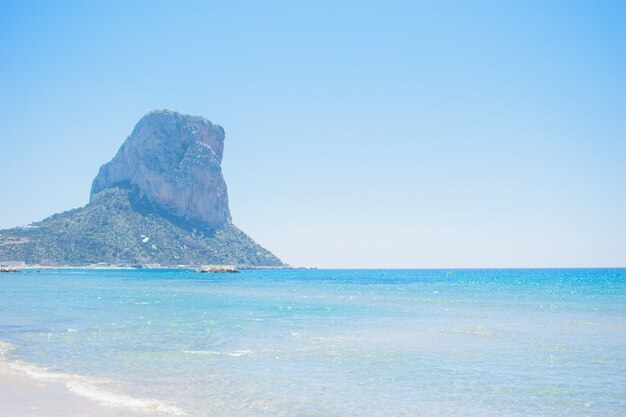 Piękny widok z plaży na słynnej skale Penon de Ifach na Costa Blanca, miasto Calpe, Hiszpania.