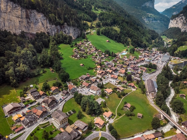 Piękny wodospad Staubbachfall spływający po malowniczej dolinie Lauterbrunnen i wiosce w kantonie Berno