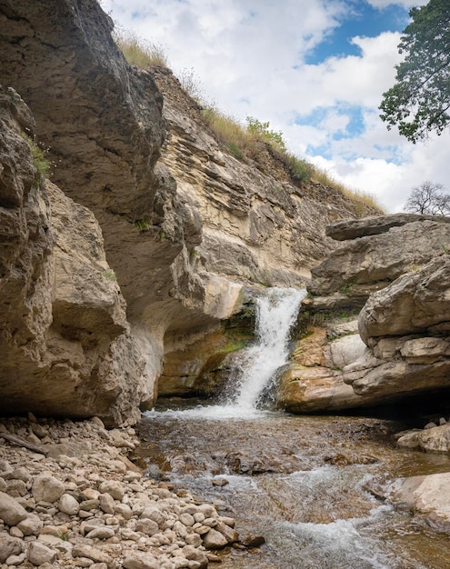 Piękny wodospad w górskim wąwozie ze skałami i czystą wodą w słoneczny letni dzień Dagestan Rosja