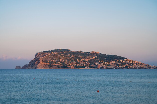 Zdjęcie piękny wschód słońca na plaży alanya z widokiem na słynną wyspę alanya w turcji