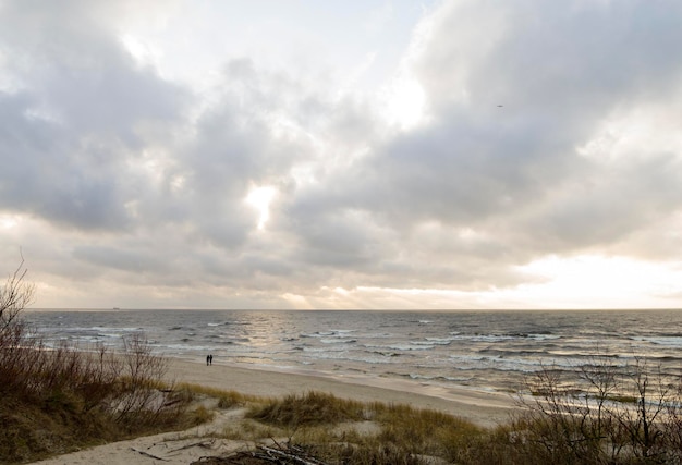 Piękny zachód słońca na piaszczystej plaży i wydmach Morza Bałtyckiego na Litwie Kłajpeda