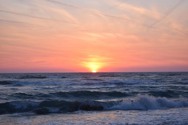Piękny zachód słońca na plaży w burzliwym oceanie