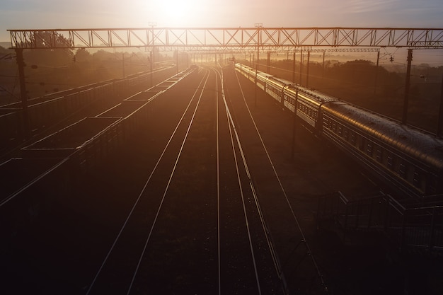 Piękny Zachód Słońca Na Stacji Kolejowej Z Pociągiem Towarowym I Pasażerskim.