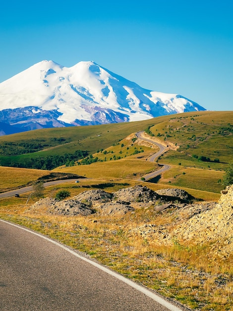 Piękny zakręt drogi przez zielone wzgórza kaukazu do elbrus