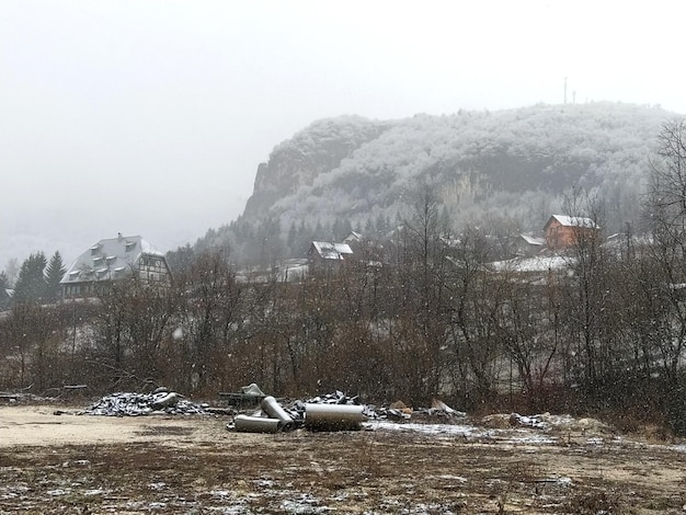 Piękny Zimowy Europejski Krajobraz Z Górą W Tle śnieg Pada W Dużych Białych Płatkach śniegu Zimowy Spokój Na Wsi Na Pierwszym Planie Jest Miejsce Brudu Z Gruzem Budowlanym