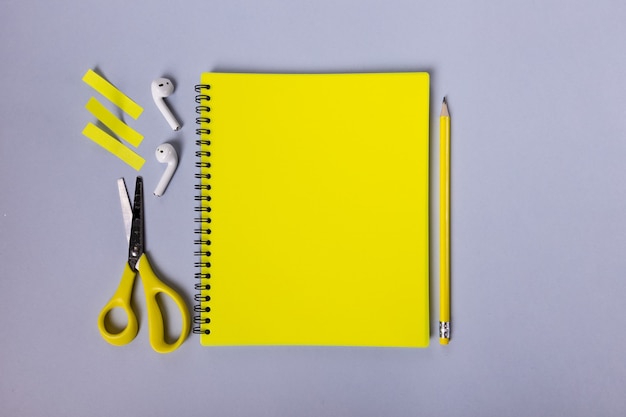 Piękny żółty układ papeterii notatnik ołówek, nożyczki, naklejki i słuchawki są piękne...