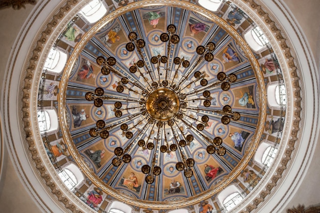 Piękny żyrandol na okrągłym malowanym suficie w kościele katolickim