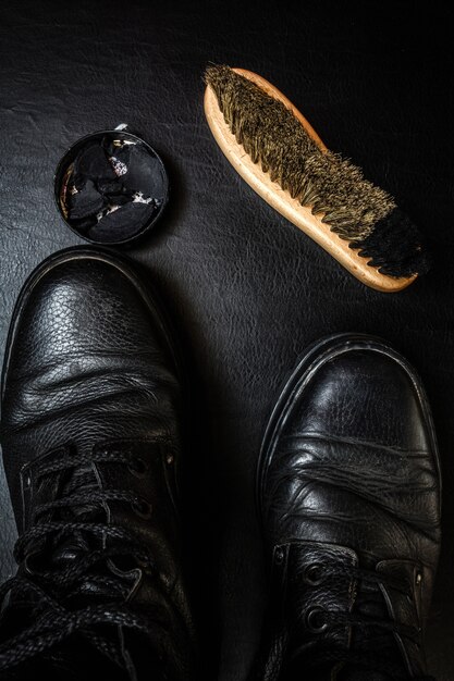 Zdjęcie pielęgnacja butów. wosk do butów, buty i szczotki na drewnianej powierzchni
