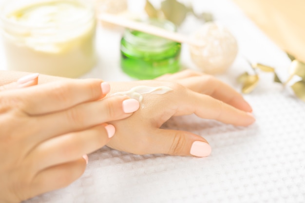 Pielęgnacja skóry dłoni. Zbliżenie piękne kobiece dłonie z naturalnych paznokci manicure. Zbliżenie Ręki Kobiety Dotykając Jej Miękkiej Jedwabiście Zdrowej Skóry. Uroda i zdrowie, koncepcja pielęgnacji ciała. selektywne skupienie