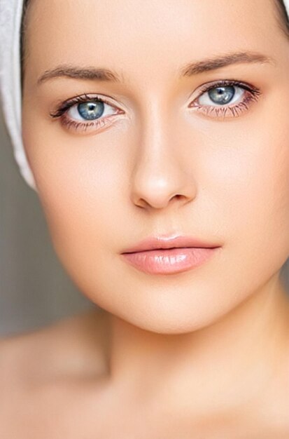 Pielęgnacja skóry i rutyna piękna piękna kobieta z białym ręcznikiem owiniętym wokół kosmetyków do pielęgnacji skóry głowy i kosmetologii twarzy