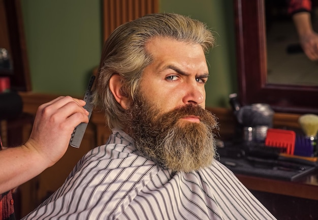 Pielęgnacja twarzy hipster z farbowaną brodą i wąsami mężczyzna chce nowej fryzury męskie piękno i moda dojrzały mężczyzna u fryzjera brutalny brodaty mężczyzna u fryzjera profesjonalny fryzjer z męskim klientem