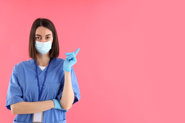 Pielęgniarka Praktykantka W Rękawiczkach I Masce Na Różowym Tle