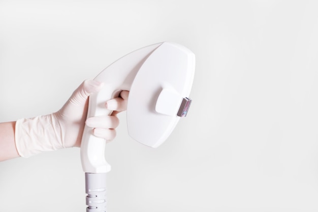 Pielęgniarka trzymająca białe rękawiczki Urządzenie Elos do depilacji