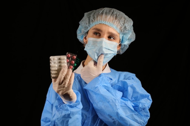Pielęgniarz-wirusolog w masce trzyma pigułki w dłoniach Szczepionka koronawirusowa Kwarantanna