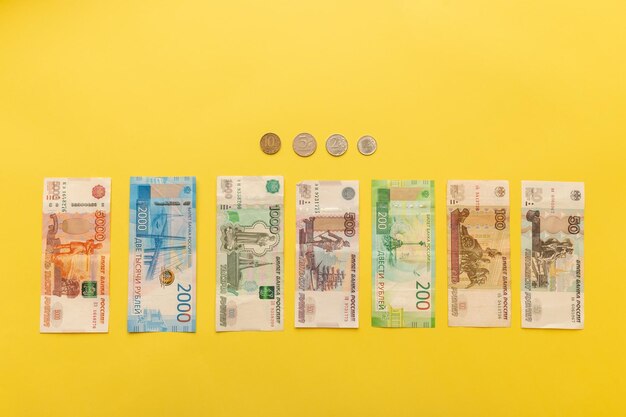 Pieniądze Rosji Banknoty i monety na żółtym tle Zbliżenie rubli rosyjskich