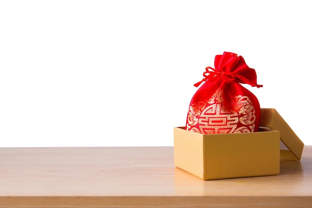 Pieniądze w czerwonej torbie na chiński nowy rok na drewnianym stole białe tło Widok z góry na deskę do projektowania wnętrz lub montażu produktu graficznego