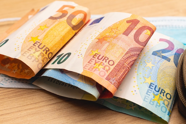 pieniądze ze złożonych banknotów euro na drewnianych meblach do koncepcji finansów i gospodarki