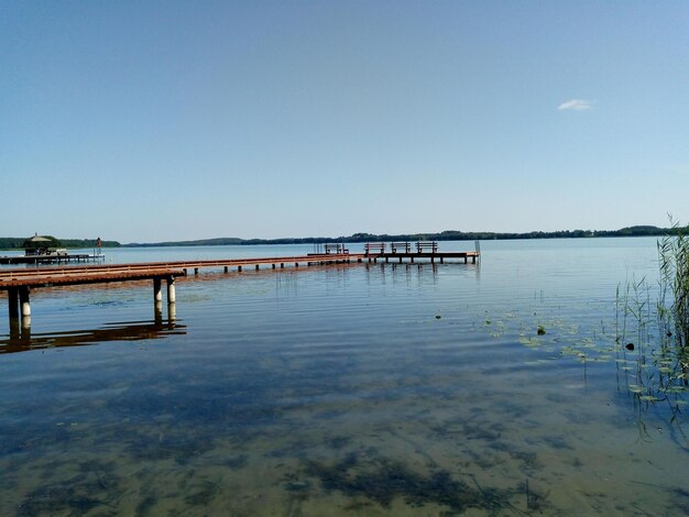 Zdjęcie pier nad jeziorem na tle jasnego niebieskiego nieba