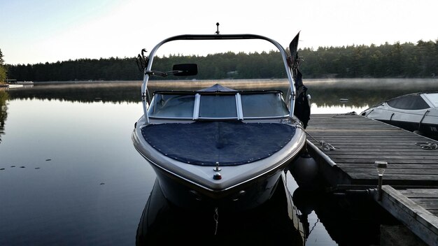 Zdjęcie pier pośród łodzi zacumowanych na spokojnym jeziorze