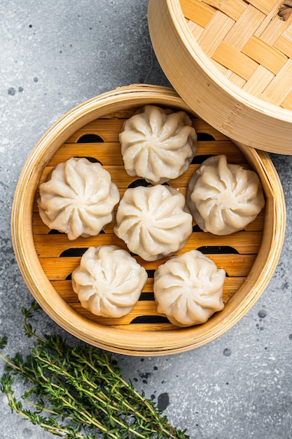 Pierogi Baozi Gotowane Na Parze Nadziewane Mięsem W Bambusowym Parowarze. Szare Tło. Widok Z Góry.