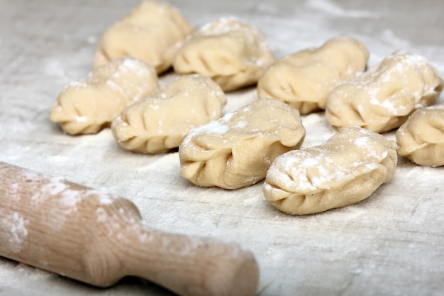 Pierogi i wałek do ciasta na stole