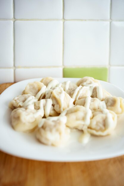 Pierogi z mięsem pelmeni rosyjskie z masłem i jogurtem.