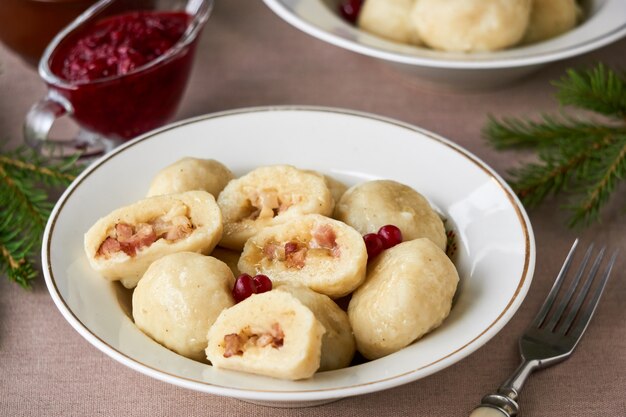 Pierogi ziemniaczane ze smażonym boczkiem, cebulą i sosem borówkowym