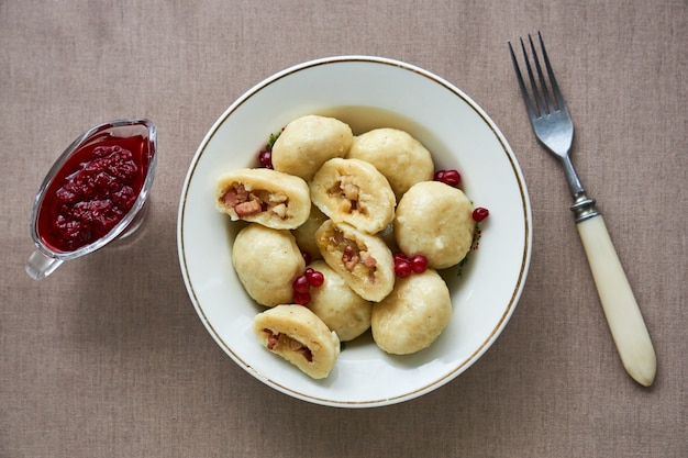 Pierogi ziemniaczane ze smażonym boczkiem, cebulą i sosem borówkowym