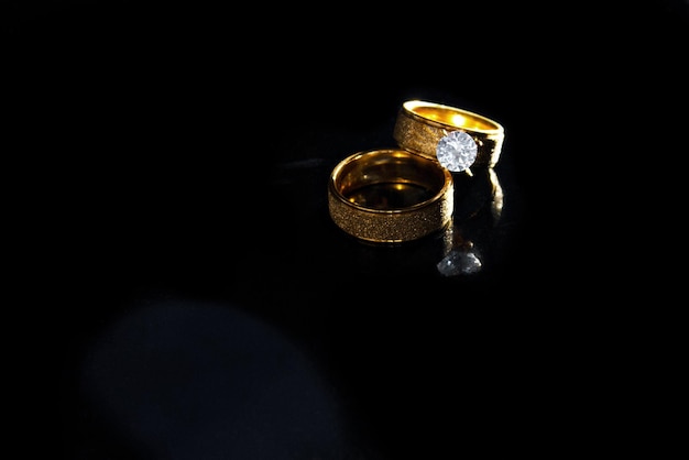 Zdjęcie pierścionki na ciemnym tle obrączki ślubne biżuteria